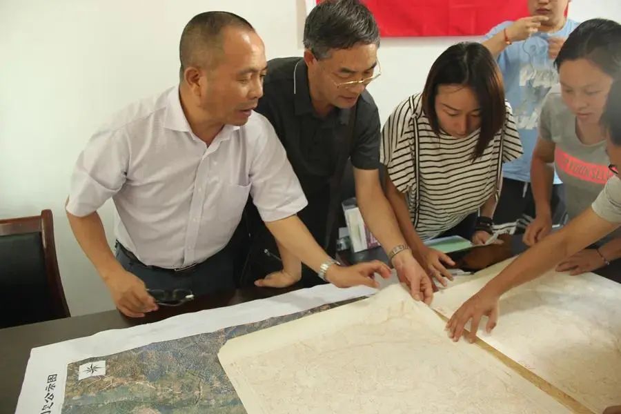 106队专家组查看大梁子地形及遥感图为土地质量调查做准备